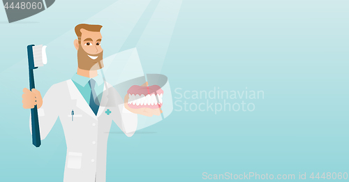 Image of Dentist with a dental jaw model and a toothbrush.