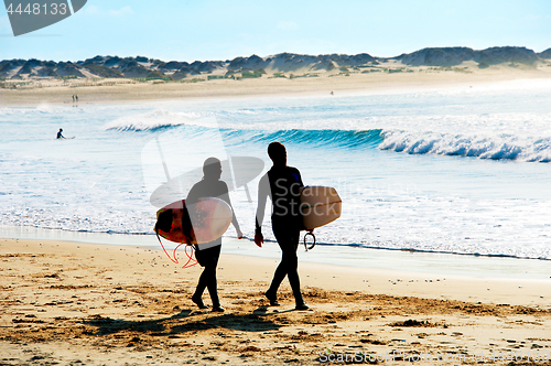 Image of Silhouette of surfers couple
