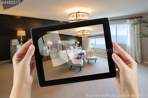 Image of Female Hands Holding Computer Tablet In Room with Photo on Scree