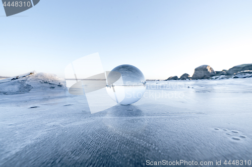 Image of Elegant glass orb on ice on a frozen lake