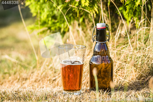 Image of Golden beer in a glass with a bottle next to