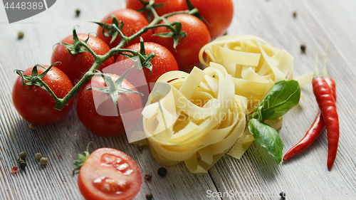 Image of Uncooked pasta bunches with tomatoes