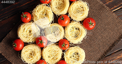 Image of Uncooked pasta bunches and tomatoes