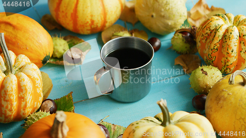 Image of Metal cup of coffee with pumpkins