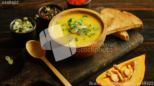 Image of Fresh pumpkin soup in bowl on chopping board