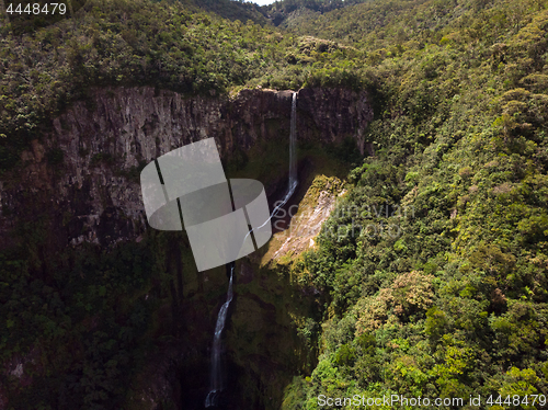 Image of Aerial top view perspective of amazing 500 feet tall waterfall in the tropical island jungle of Mauritius.