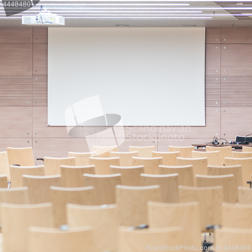 Image of Empty wooden seats in a cotmporary lecture hall.