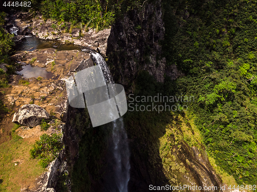 Image of Aerial top view perspective of amazing 500 feet tall waterfall in the tropical island jungle of Mauritius.