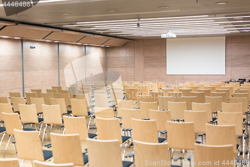 Image of Empty wooden seats in a cotmporary lecture hall.