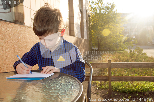 Image of Boy doing homework outdoors