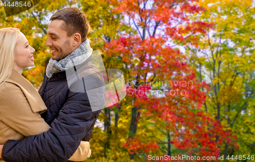 Image of smiling couple hugging in autumn park