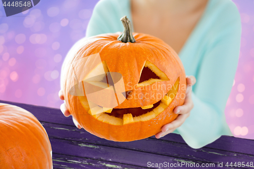 Image of close up of woman with halloween pumpkin