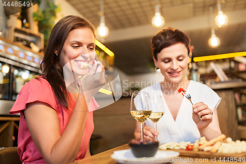 Image of women eating snacks at wine bar or restaurant