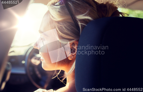 Image of happy teenage girl or young woman in car