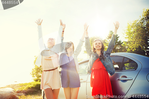 Image of happy teenage girls or women near car at seaside