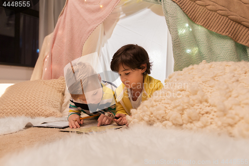 Image of boys with magnifier and map in kids tent at home