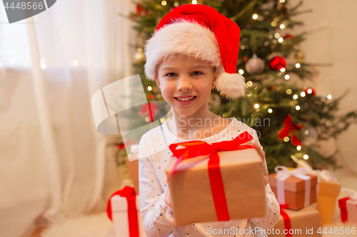 Image of smiling girl in santa hat with christmas gift