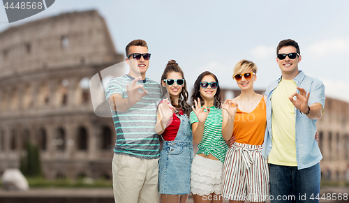 Image of friends in sunglasses showing ok over coliseum