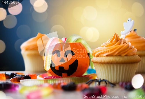 Image of halloween party decorated cupcakes on wooden table