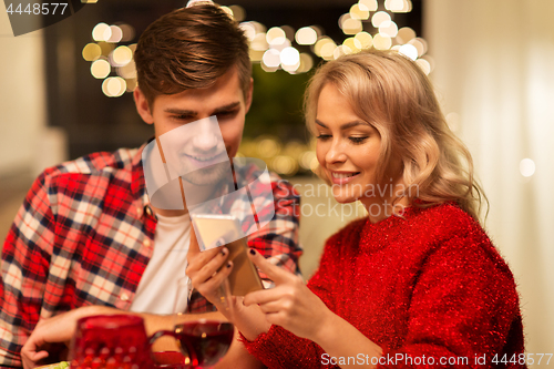 Image of couple with smartphone at home christmas dinner