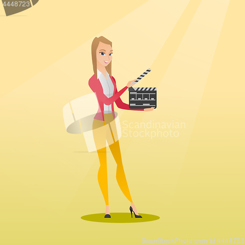 Image of Smiling woman holding an open clapperboard.