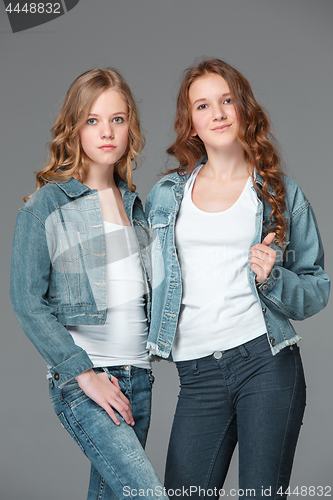 Image of Full length of young slim female girl in denim jeans on gray background