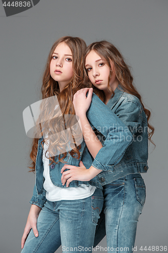 Image of Full length of young slim female girl in denim jeans on gray background