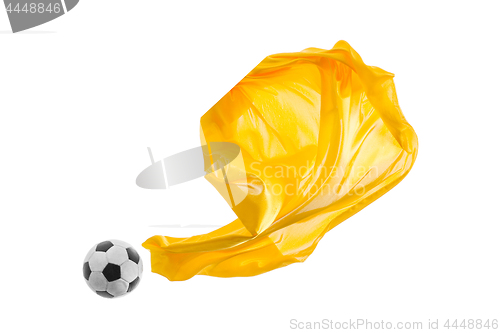 Image of Soccer ball and Smooth elegant transparent yellow cloth isolated or separated on white studio background.