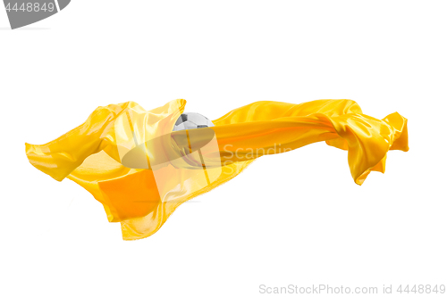 Image of Soccer ball and Smooth elegant transparent yellow cloth isolated or separated on white studio background.