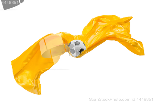 Image of Soccer ball and Smooth elegant transparent yellow cloth isolated or separated on white studio background.