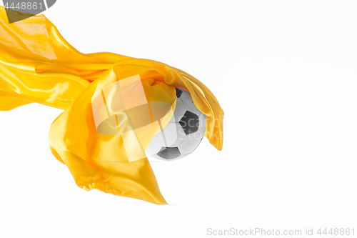 Image of Soccer ball and Smooth elegant transparent yellow cloth isolated