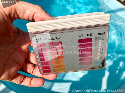 Image of checking pH level in blue outdoor pool