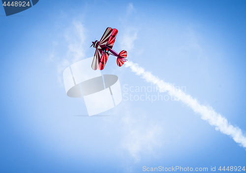 Image of Red plane with propeller flying upward