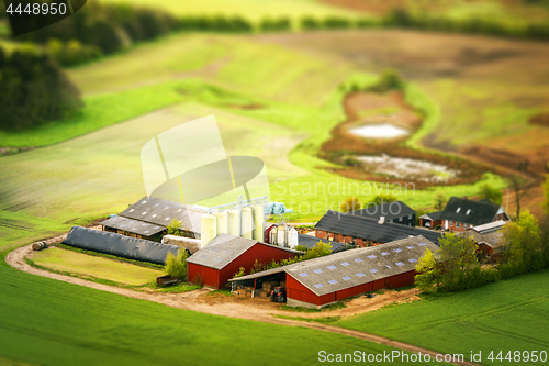 Image of Rural farm in red colors with green fields