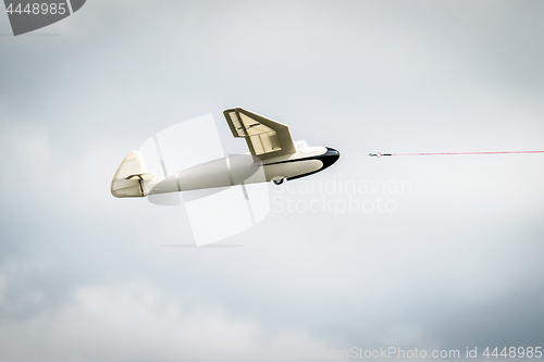 Image of Small glider airplane with a line
