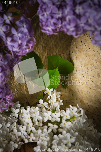 Image of Still-life with a bouquet of lilacs and a straw hat, close-up