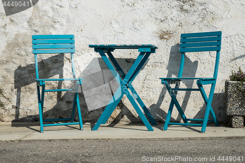 Image of pictoresque blue chairs on a street