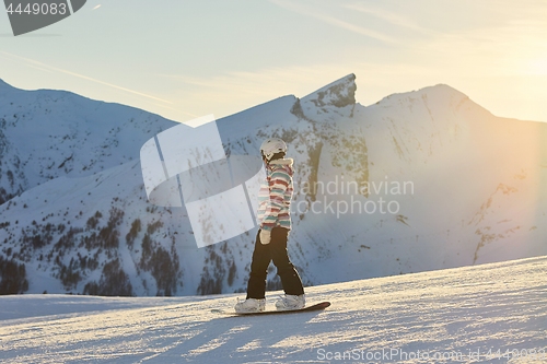 Image of Female snowboarder in sun flare