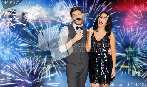 Image of happy couple with party props having fun