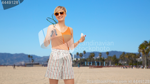 Image of teenager with badminton rackets and shuttlecock