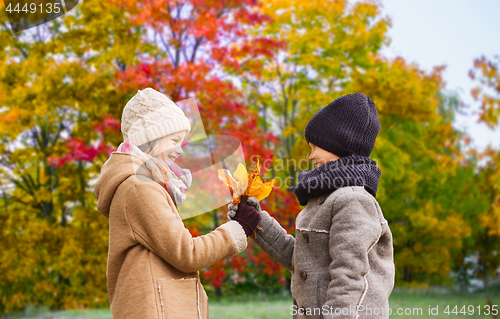 Image of kids with autumn maple leaves over park background