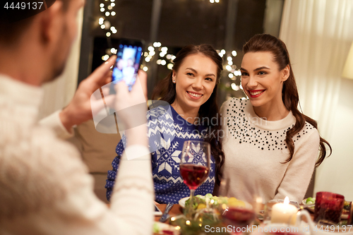 Image of friends having christmas dinner and taking picture