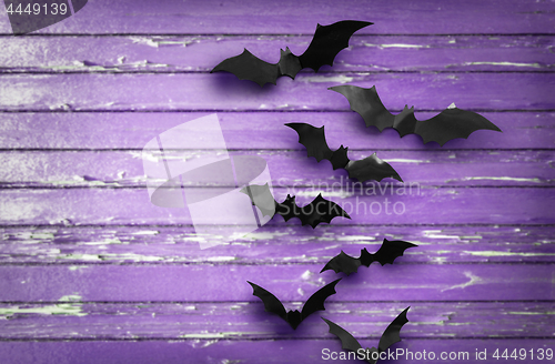 Image of black bats over ultra violet shabby boards