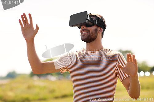 Image of smiling man in virtual reality headset outdoors