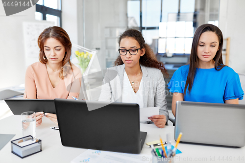 Image of businesswomen with tablet pc and laptops at office