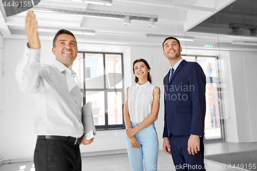 Image of realtor showing new office room to customers