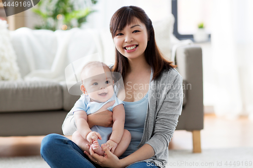 Image of happy young mother with little baby at home