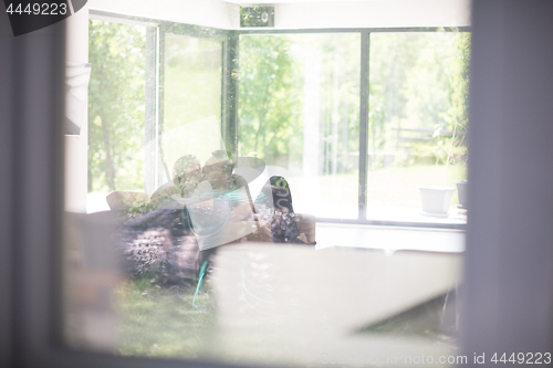 Image of couple relaxing at  home with tablet and laptop computers