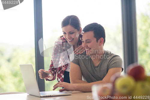 Image of happy young couple buying online