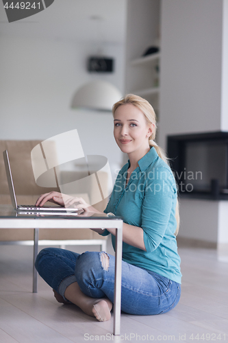 Image of young women using laptop computer on the floor